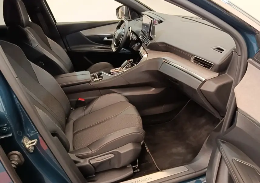 Vue intérieure côté passager avant d’un Peugeot 3008 bleu avec sièges noirs et tableau de bord moderne.