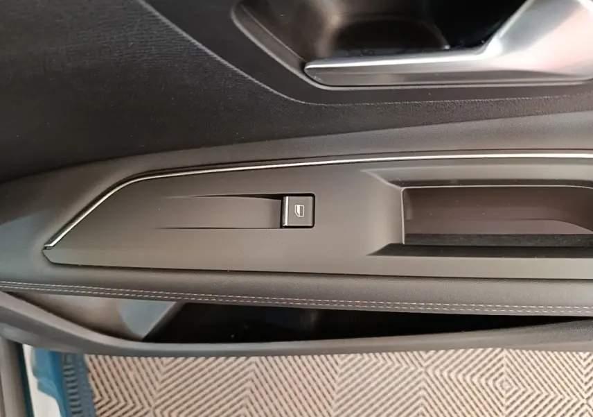 Gros plan sur la commande de lève-vitre côté gauche de la porte intérieure noire du Peugeot 3008 hybride bleu.