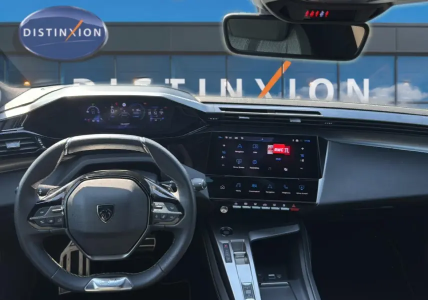 Vue intérieure centrée sur le volant multifonction et l’écran tactile du tableau de bord de la Peugeot 308 gris 2025.