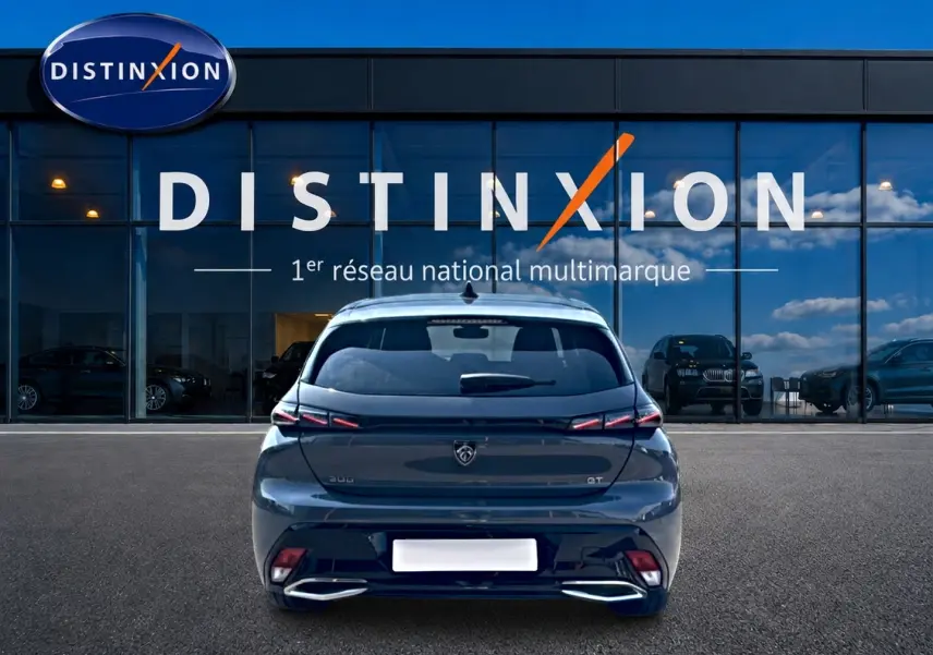 Vue arrière d'une Peugeot 308 gris métallisé 2025 GT avec feux LED et double sortie d'échappement chromée.