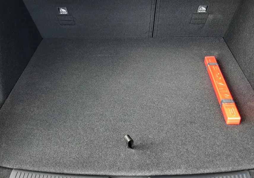 Vue plongeante sur le coffre spacieux et propre du MG MOTOR EHS Camden Grey 2026, avec triangle de signalisation rouge visible.