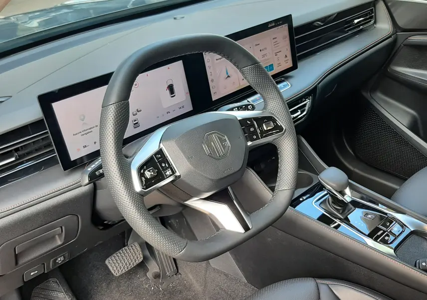 Vue intérieure côté conducteur du MG MOTOR EHS 1.5 HYBRID+ 224CH LUXURY 2026, volant cuir noir et double écran digital.