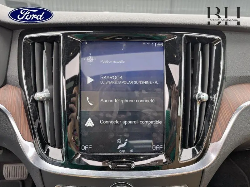 Vue rapprochée de l'écran tactile central et des aérateurs noirs du tableau de bord d'une Volvo V60 gris Savile métallisé.