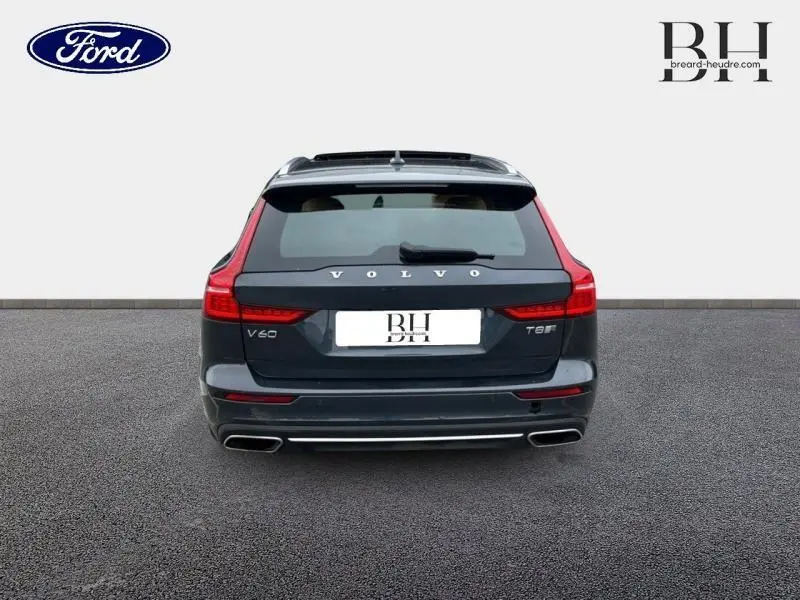 Vue arrière d'une Volvo V60 T8 hybride rechargeable gris Savile métallisé avec feux arrière LED et double sortie d'échappement chromée.