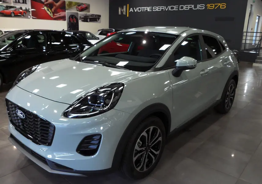 Ford Puma gris Cactus en 3/4 avant droit, avec phares LED et jantes bi-ton 17 pouces en showroom.