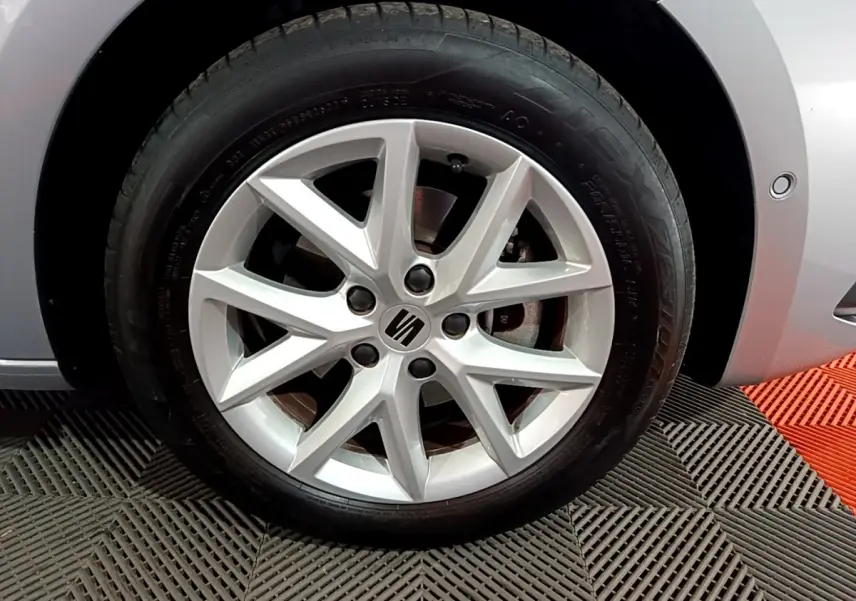 Gros plan sur la jante alliage argentée côté avant droit d'une SEAT LEON gris clair 2023 avec logo central visible.