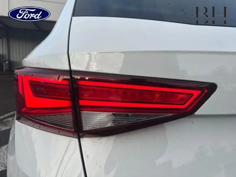 Gros plan sur le feu arrière gauche rouge et blanc d’un SEAT Ateca blanc Nevada Métal, vue arrière côté gauche.