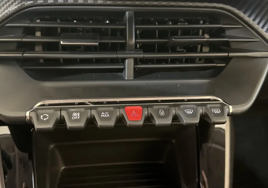 Gros plan sur la rangée de boutons de commande de la climatisation et des alertes dans l’habitacle d’une Peugeot 208 2020.