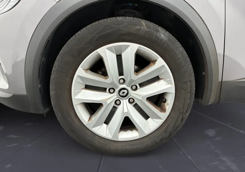 Gros plan sur la roue avant gauche d’un Renault Captur gris Cassiopée avec jante alliage à cinq doubles branches.