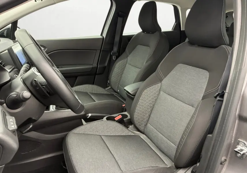 Vue intérieure côté conducteur du Renault Captur 2022 avec sièges tissu noir et gris à surpiqûres blanches.