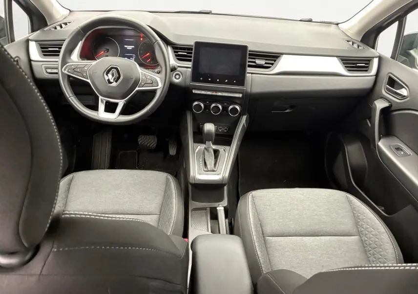 Vue intérieure avant du Renault Captur TCE 140 Business 2022, sellerie tissu gris et tableau de bord noir.