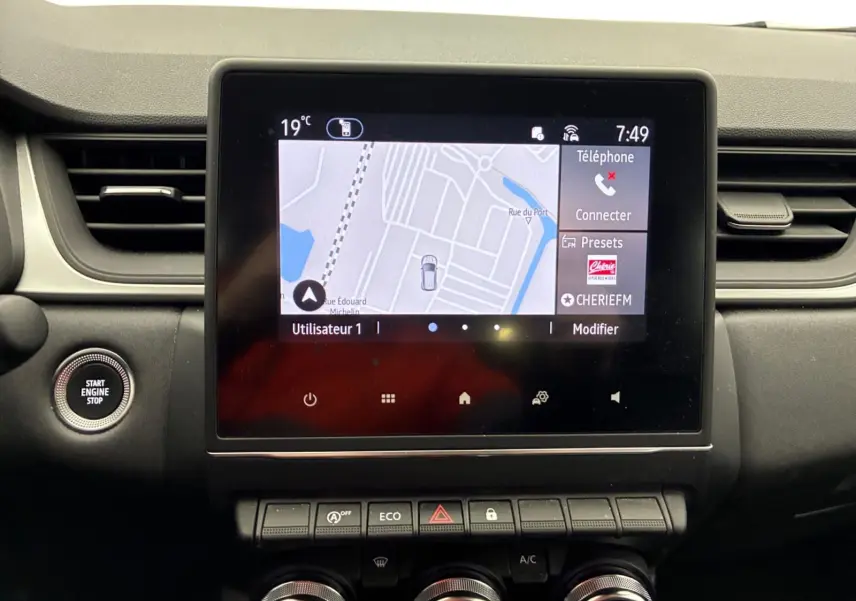 Écran tactile central avec navigation affichée, boutons de commande en dessous, intérieur noir du Renault Captur 2022.