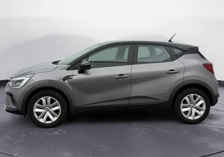 Profil côté gauche du Renault Captur 2022 gris Cassiopée avec toit noir et roue de secours visible.
