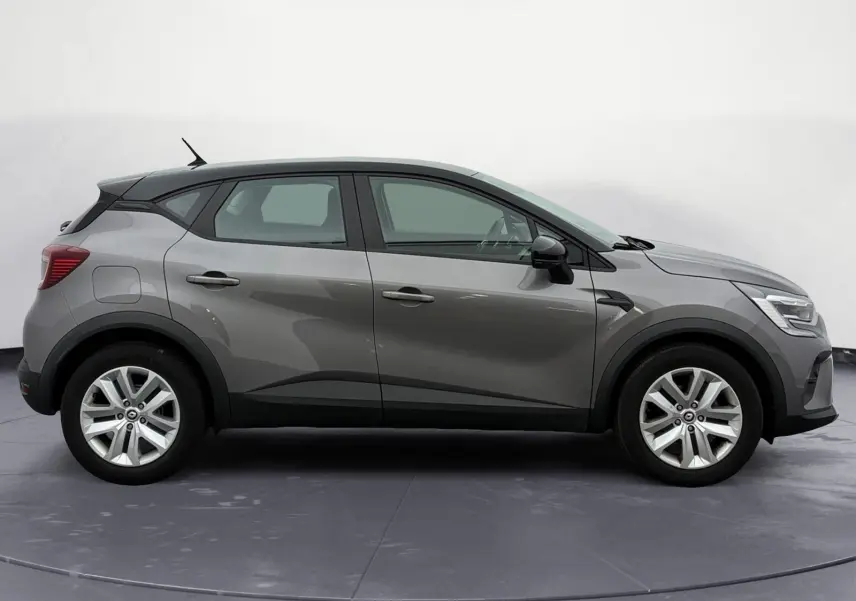 Profil droit du Renault Captur TCE 140 EDC 21 Business gris Cassiopée avec toit noir et roue de secours visible.