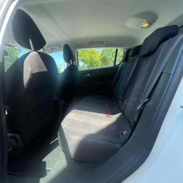 Vue intérieure côté droit des sièges arrière noirs d'une Peugeot 308 blanche de 2020, avec ceinture de sécurité visible.