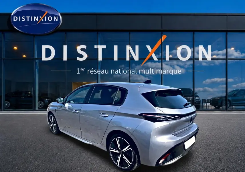 Peugeot 308 gris en 3/4 arrière droit, mettant en valeur ses jantes alu et feux arrière LED distinctifs.