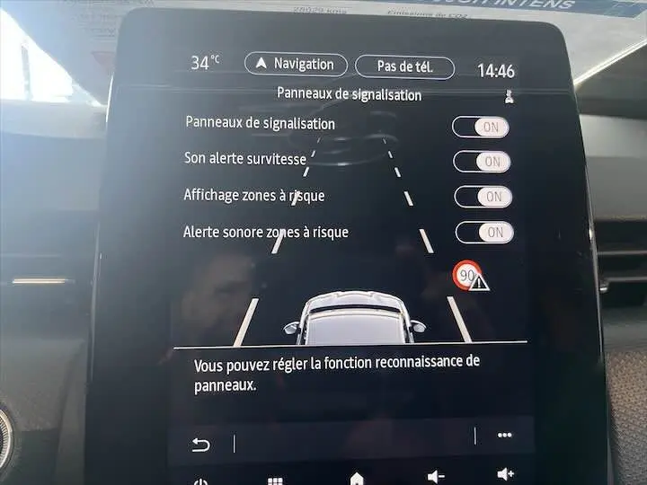 Écran tactile intérieur de la Renault Clio V blanc nacré montrant les réglages d'alerte panneaux de signalisation.