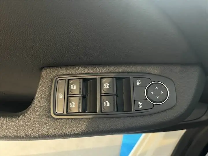 Commande des vitres et réglage des rétroviseurs côté conducteur de la Renault Clio V blanc nacré, vue en gros plan intérieur.