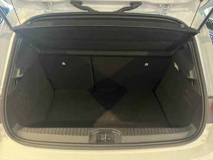 Coffre ouvert d'une Renault Clio V blanc nacré, vue intérieure montrant l'espace de chargement vide.