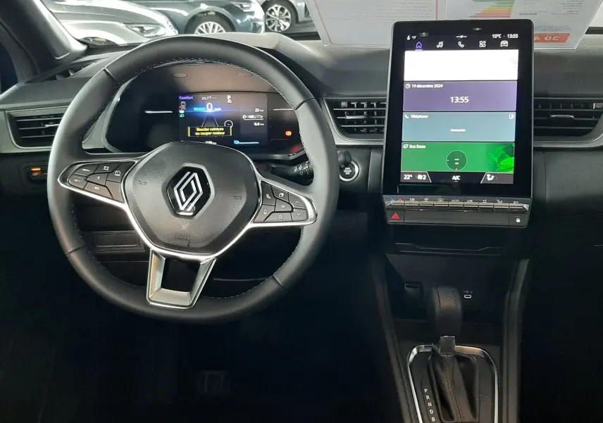 Vue intérieure du tableau de bord du Renault Captur E-Tech Hybrid 2024, avec volant multifonction et écran tactile vertical.