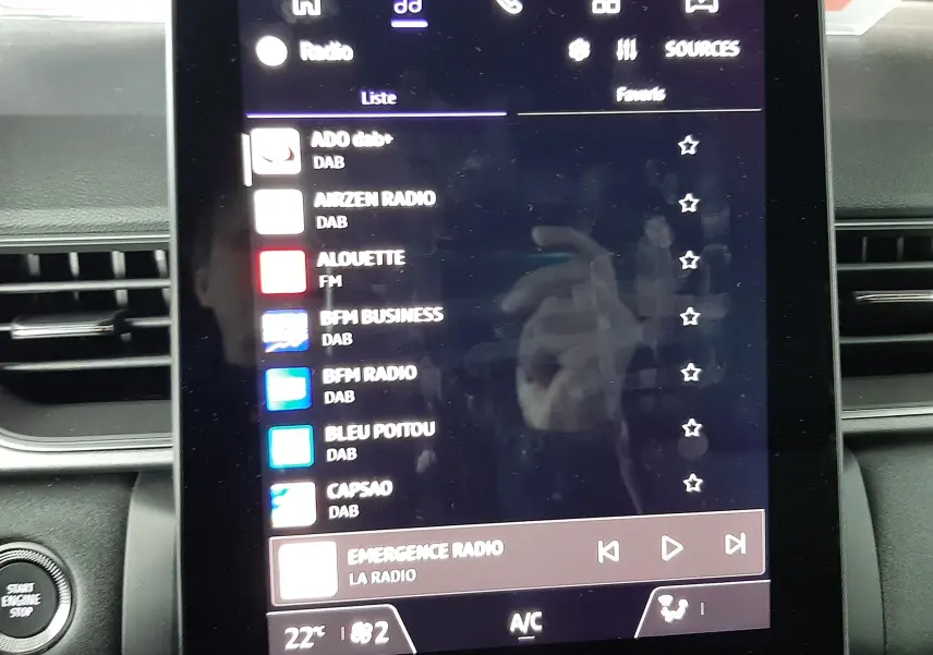 Écran tactile central du tableau de bord du Renault Captur E-Tech Hybrid 2024 affichant les stations radio DAB.