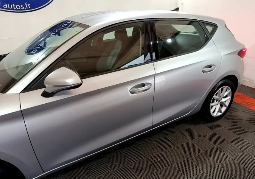 Profil côté gauche d'une SEAT Leon gris foncé 2023, mettant en valeur les lignes épurées et les jantes alliage.