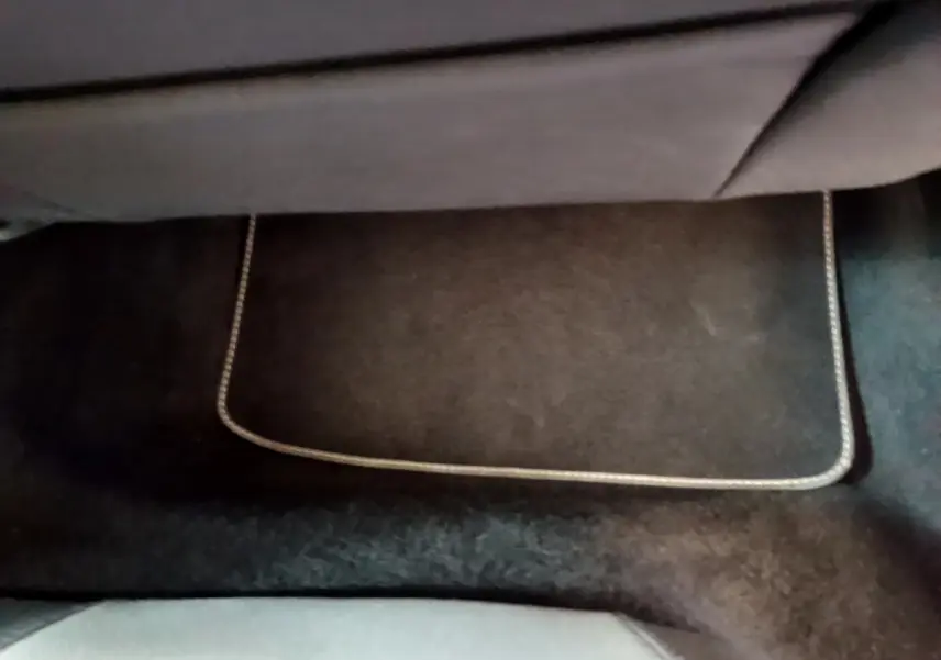 Tapis de sol noir avec surpiqûres claires dans l'habitacle arrière d'une SEAT Leon gris foncé 2023.