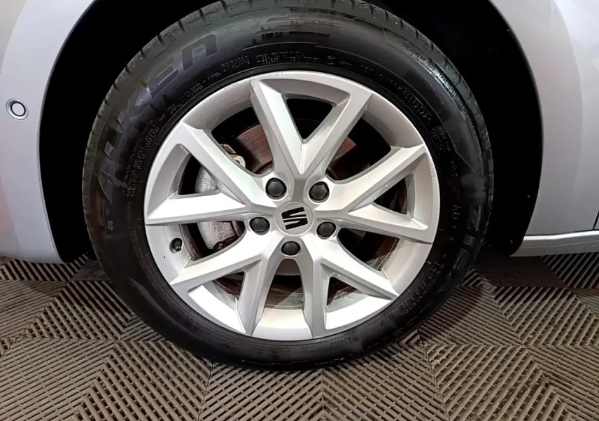 Gros plan sur la roue avant droite gris foncé d'une SEAT LEON 2023 avec jante alliage à 5 doubles branches.