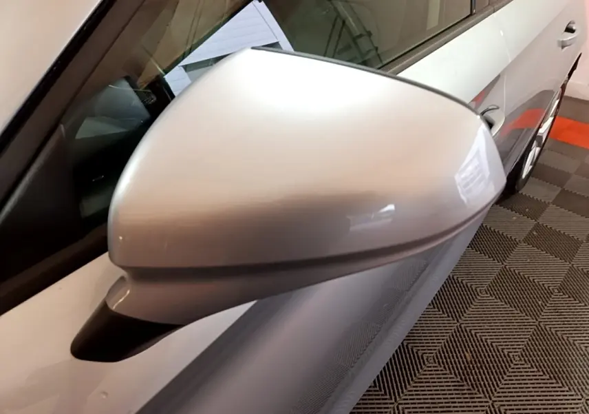 Gros plan sur le rétroviseur côté gauche gris foncé d'une SEAT LEON 2023, avec partie latérale et vitre visible.