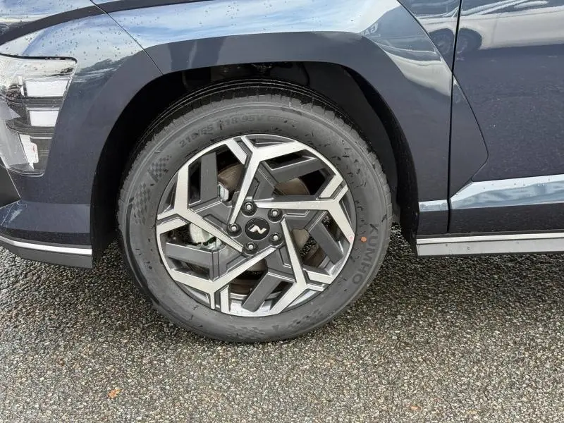 Gros plan sur la roue avant gauche du Hyundai Kona 2025 Cyber Gray métallisé avec jante alu au design géométrique.