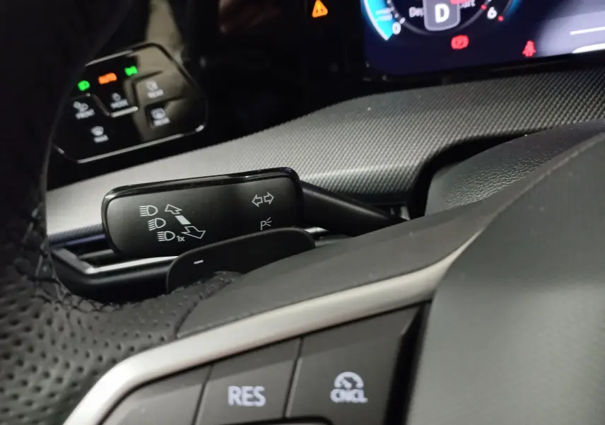 Gros plan sur le volant et commandes du tableau de bord d'une Volkswagen Golf 2.0 TDI 150 DSG7 R-Line, intérieur noir.