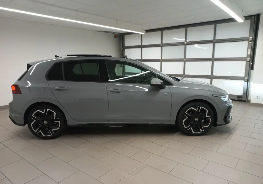 Volkswagen Golf 2.0 TDI R-Line gris lunaire vue de profil côté gauche en intérieur avec toit ouvrant panoramique.