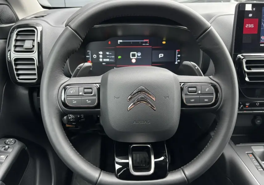 Vue rapprochée du volant cuir noir et du combiné numérique du tableau de bord du Citroën C5 Aircross 2025.