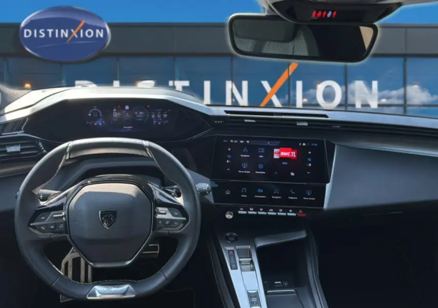 Vue intérieure avant de la Peugeot 308 gris 2025, avec tableau de bord numérique et écran tactile central allumé.
