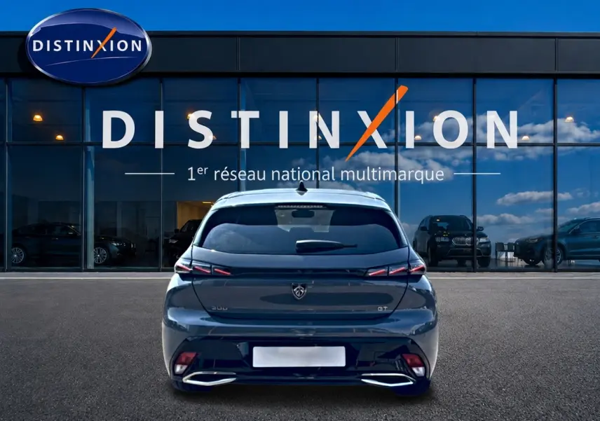 Vue arrière d'une Peugeot 308 gris métallisé 2025 avec feux arrière LED et double sortie d'échappement chromée.