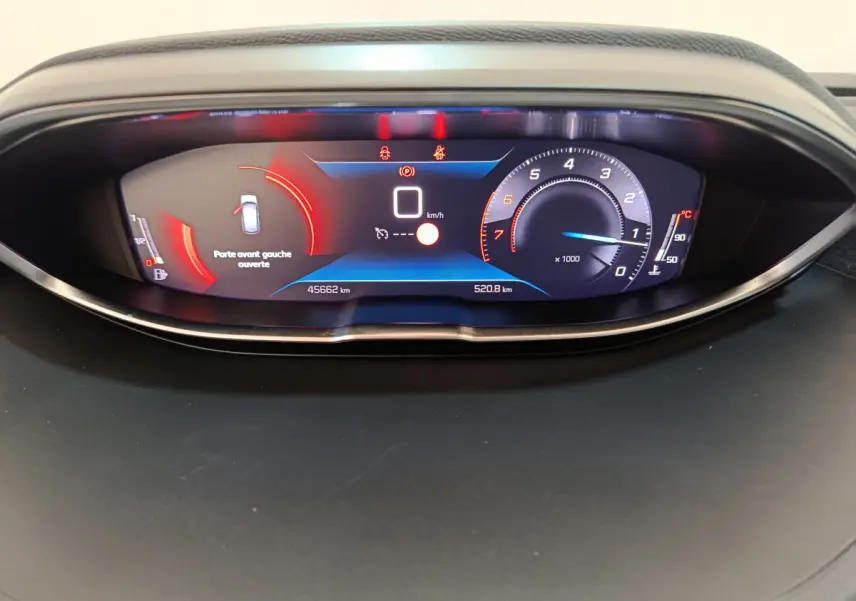 Gros plan sur le tableau de bord numérique du Peugeot 3008 bleu, affichant la vitesse à 0 km/h et porte avant gauche ouverte.