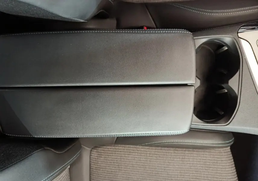 Gros plan sur l'accoudoir central noir et porte-gobelets du Peugeot 3008 PureTech 130 S&S Allure 2022.