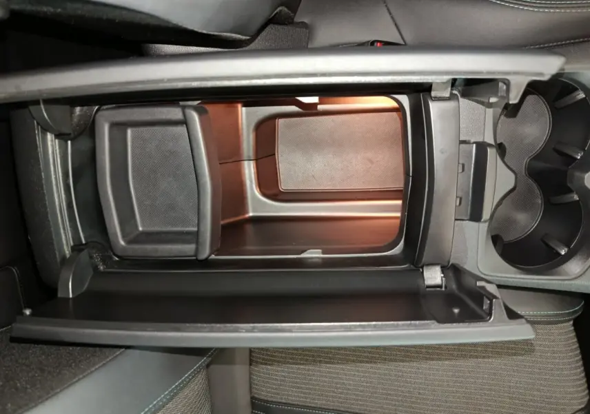 Intérieur du Peugeot 3008 PureTech 130 S&S Allure 2022, vue plongeante sur la console centrale avec rangement ouvert.