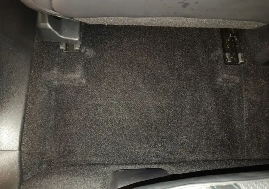 Vue rapprochée du sol côté passager avant du Peugeot 3008 bleu, montrant la moquette noire et les rails du siège.