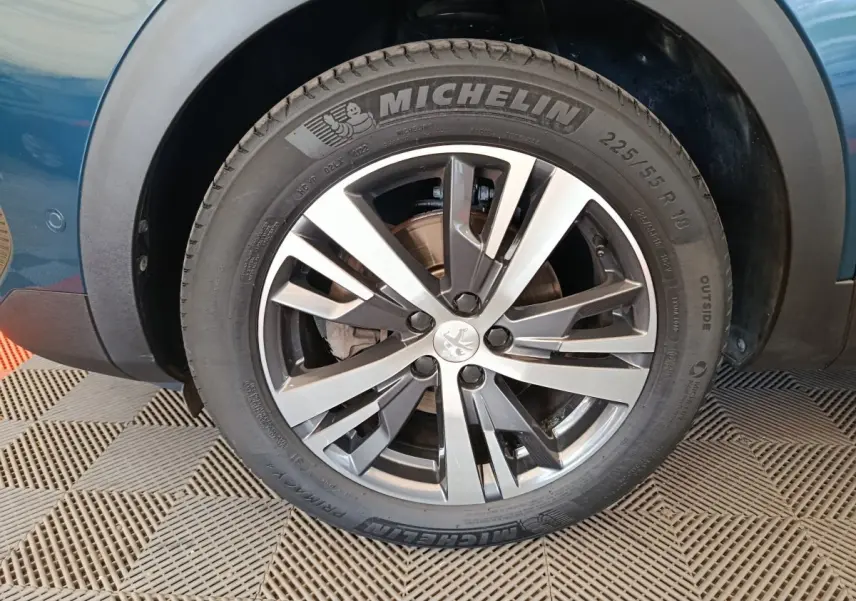 Gros plan sur la roue avant gauche du Peugeot 3008 bleu 2022 avec jante alliage et pneu Michelin visible.