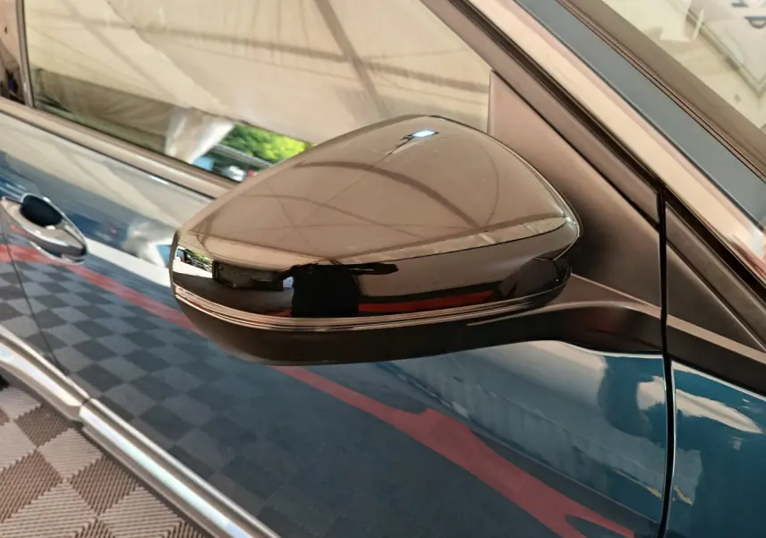 Rétroviseur côté droit noir brillant sur Peugeot 3008 bleu, vue rapprochée du profil avant du véhicule.