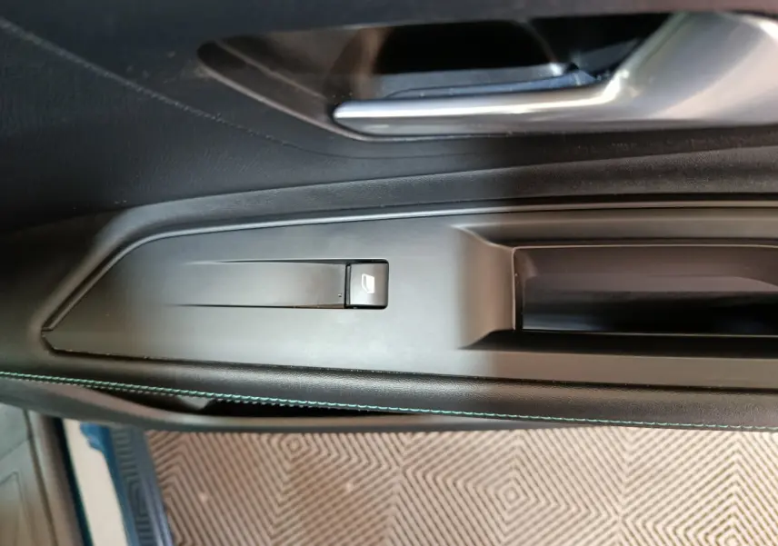Détail de la poignée intérieure côté gauche noire avec bouton de lève-vitre sur Peugeot 3008 PureTech 130 S&S Allure 2022.