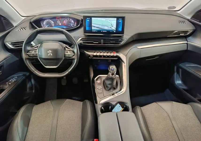 Vue intérieure avant du Peugeot 3008 bleu 2022, tableau de bord moderne avec écran tactile et volant cuir multifonctions.