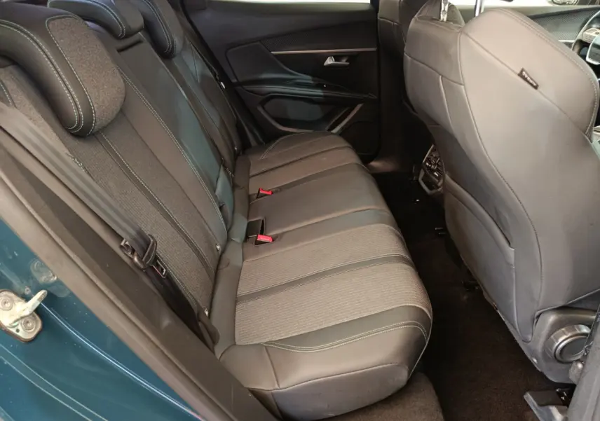 Vue côté gauche sur la banquette arrière en tissu et cuir du Peugeot 3008 bleu, avec appuie-têtes et ceintures visibles.