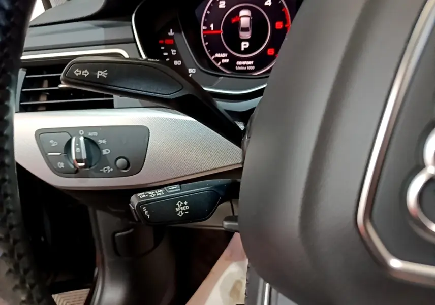 Gros plan sur le volant cuir noir et le tableau de bord numérique rouge de l'Audi A4 40 TDI 2018 côté conducteur.