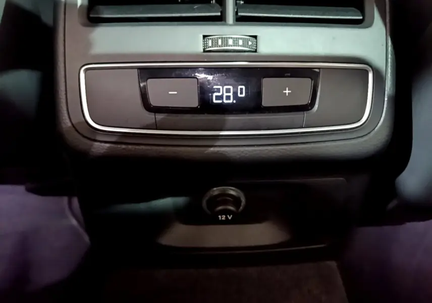 Gros plan sur la commande de climatisation arrière affichant 28°C et prise 12V dans l'Audi A4 noire 2018 Design Luxe.