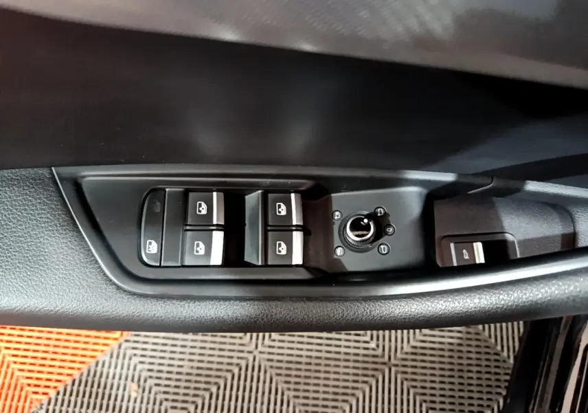 Panneau de commandes des vitres et rétroviseurs côté conducteur d'une Audi A4 noire, vue intérieure rapprochée.