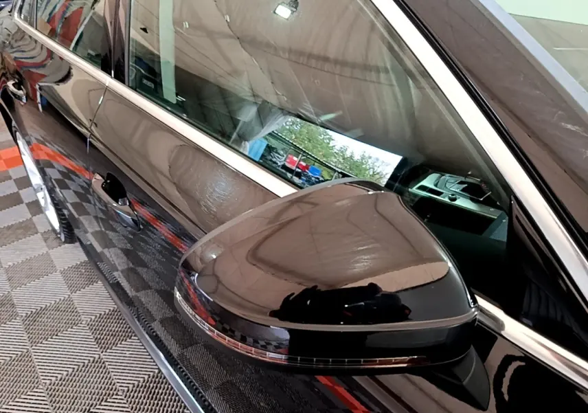 Rétroviseur noir brillant côté gauche d'une Audi A4 40 TDI 190 Quat S tronic Design Luxe 2018 avec carrosserie noire.