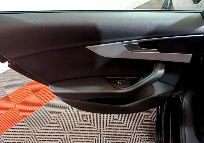 Vue rapprochée de la porte côté gauche noire de l'Audi A4 40 TDI 2018 avec insert argenté et commande de vitre électrique.