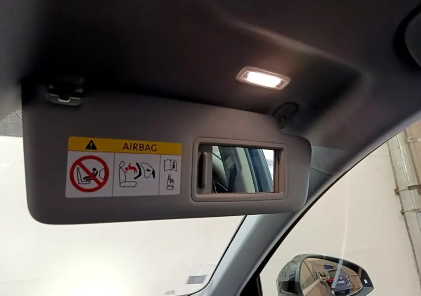 Miroir de courtoisie sur pare-soleil côté conducteur de l'Audi A4 noire, intérieur éclairé, rétroviseur visible.